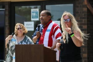 Executive Director Mark Pierce addressing the crowd with an ASL Interpreter and Laurie Parker