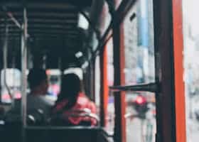 Blurred view inside a Hong Kong double-decker bus with commuters showing city life.